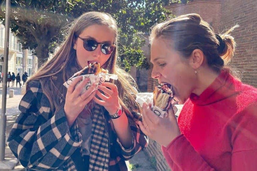 Toulouse: Guided Food Tour + Tasting Two women eating sandwiches in the street