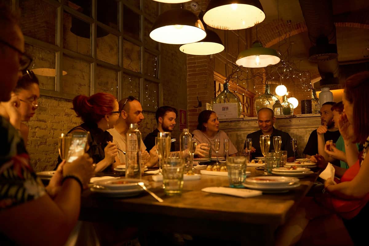 Group enjoying a cozy dinner experience in a warm, inviting restaurant setting in el Born, Barcelona.