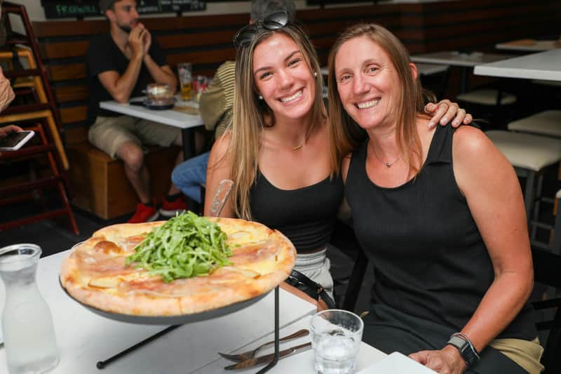 Smiling with gourmet pizza